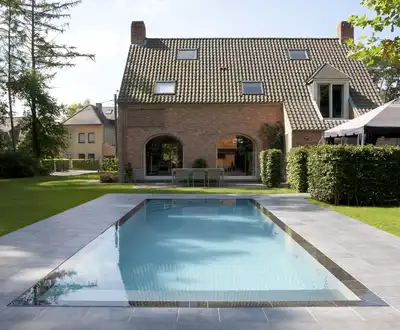 "Modern brick home with swimming pool and landscaped garden, showcasing durable construction materials" [G]