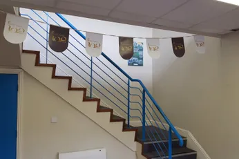 "Staircase with decorative banner flags featuring the Scott Bader logo in an office environment" [G]