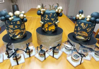"Elegant celebration display with Scott Bader logo featuring decorative blue and gold centerpieces and gift boxes on wooden table" [G]