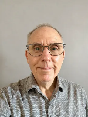 Portrait of a man wearing glasses and a patterned shirt, associated with Scott Bader. [G]