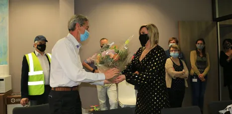 "Professional presentation ceremony at Scott Bader facility with team members observing in safety equipment" [G]
