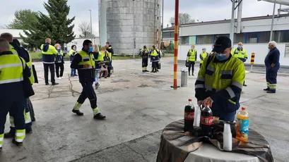 "Industrial facility workers in high-visibility safety gear at Scott Bader manufacturing site where resins and composites are produced." [G]