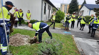 "Scott Bader team in high-visibility vests participating in a landscaping activity at company facility, demonstrating environmental commitment." [G]
