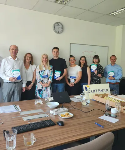 "Scott Bader team meeting with product samples and company branding visible on conference table" [G]