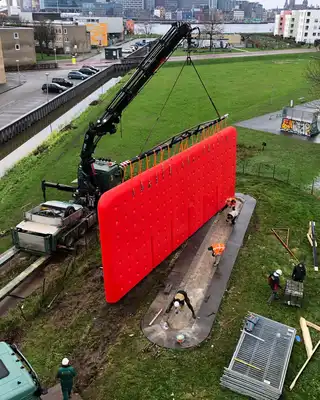 "Crane installing bright red composite panel in urban development area, showcasing Scott Bader structural adhesives and resins" [G]