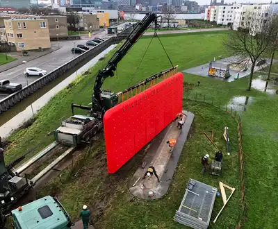 "Crane installing bright red composite panel in urban development area, showcasing Scott Bader structural adhesives and resins" [G]