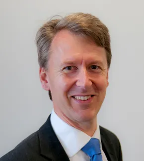 Portrait of a smiling professional in a suit, representing Scott Bader leadership team. [G]