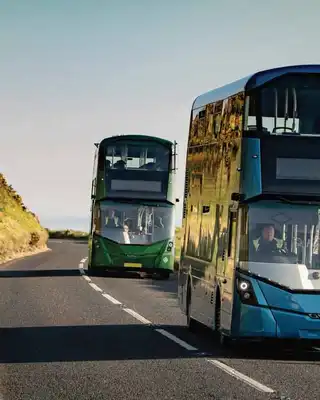 "Modern double-decker buses traveling on coastal road, showcasing Scott Bader composites used in transportation applications" [G]