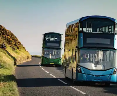 "Modern double-decker buses traveling on coastal road, showcasing Scott Bader composites used in transportation applications" [G]