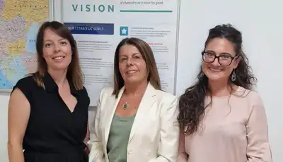 "Professional team in Scott Bader office with European map and vision statement display in background" [G]