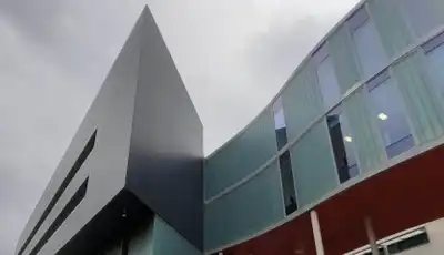 "Modern architectural building with glass panels and angular design, featuring Scott Bader's innovative composites and structural adhesives" [G]