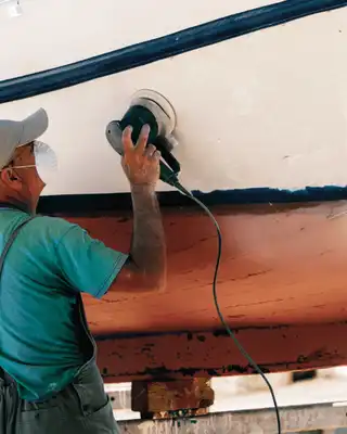 "Worker polishing boat hull with Scott Bader gelcoats and composites for marine applications, featuring Crystic products" [G]