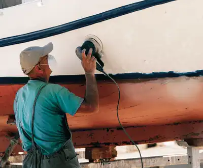 "Worker polishing boat hull with Scott Bader gelcoats and composites for marine applications, featuring Crystic products" [G]