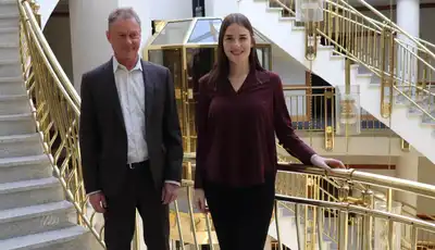 "Interior of modern office building with elegant staircase featuring gold railings at Scott Bader headquarters" [G]