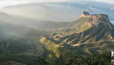 "Panoramic mountain landscape with sunlight streaming across rugged terrain, featuring Scott Bader logo - Making a positive difference" [G]