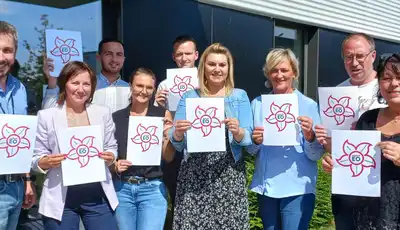 "Scott Bader team members displaying branded materials outside company facility, showcasing the composites and adhesives manufacturer" [G]