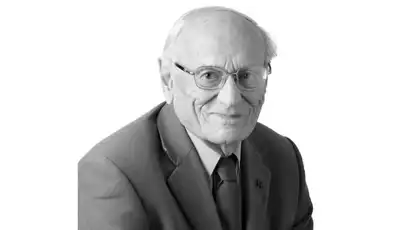 "Professional portrait of an elderly gentleman in a suit and tie, associated with Scott Bader's leadership in composites and adhesives" [G]