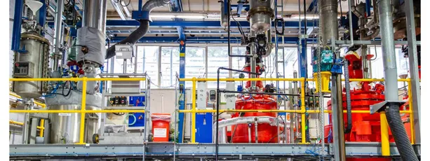 "Industrial manufacturing facility with red processing equipment and complex piping system for Scott Bader resins and composites production" [G]