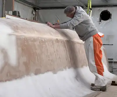 Worker sanding a boat hull mould, Scott Bader composites and resins for marine manufacturing [G]