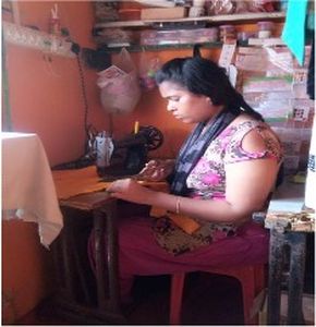 "Person working at sewing machine in small workshop with shelves of materials and supplies in background" [G]