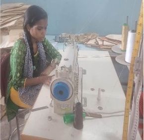 "Textile worker operating a sewing machine in a manufacturing workshop with fabric materials and supplies" [G]