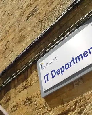 "IT Department sign on stone building exterior, part of Scott Bader's facility" [G]