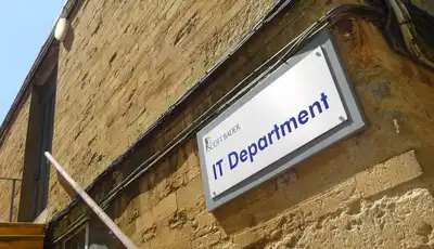 "IT Department sign on stone building exterior, part of Scott Bader's facility" [G]