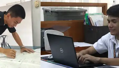 "Two professionals working in a Scott Bader office environment - one examining documents while another uses a laptop" [G]