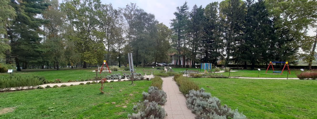 "Landscaped park area with stone-lined pathway, green lawns, and decorative plants surrounding Scott Bader facility" [G]