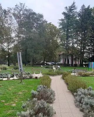 "Landscaped park area with stone-lined pathway, green lawns, and decorative plants surrounding Scott Bader facility" [G]
