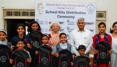 "School kits distribution ceremony with children holding backpacks, sponsored by Scott Bader and other organizations supporting education initiatives." [G]