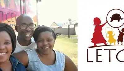 "Group photo at LETCEE community event with organization logo showing silhouettes of children and caregiver" [G]