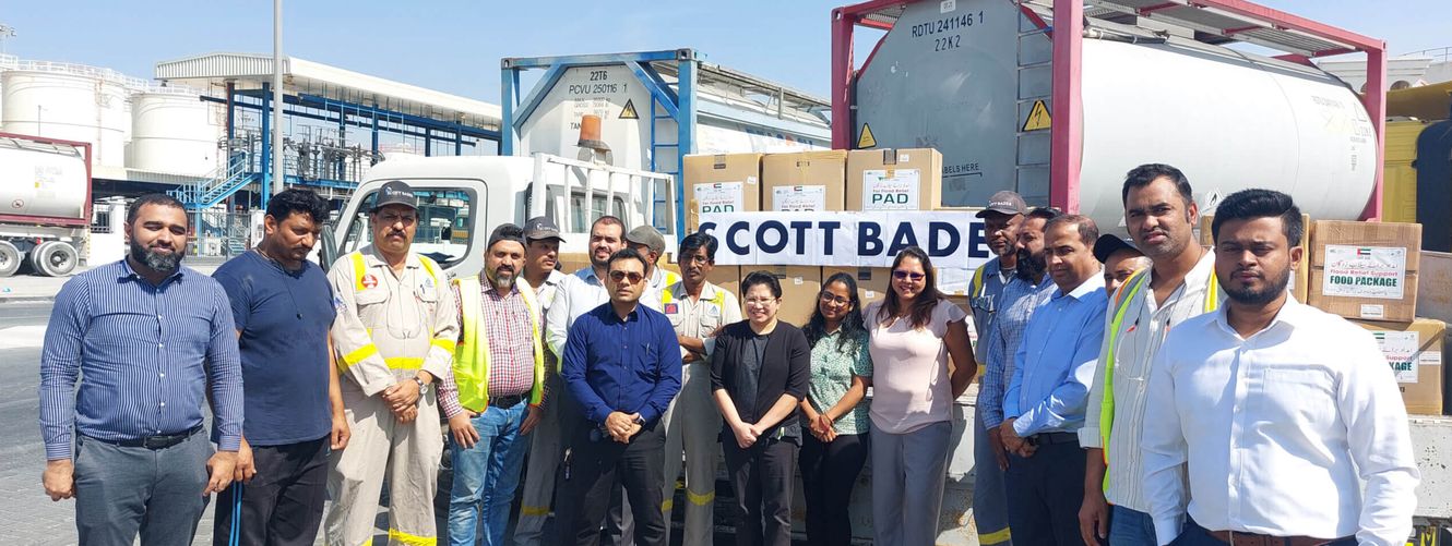 "Team of professionals at Scott Bader manufacturing facility with storage tanks for resins and composites production" [G]