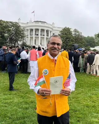 "Outdoor gathering on the White House lawn with attendees in formal attire and traditional clothing during an official event" [G]