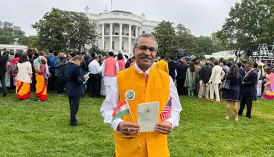 "Outdoor gathering on the White House lawn with attendees in formal attire and traditional clothing during an official event" [G]