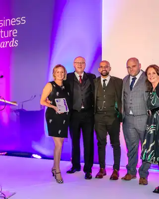 "Scott Bader representatives receiving an award at the Business Culture Awards ceremony, showcasing company excellence" [G]