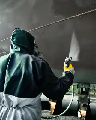 "Worker applying Scott Bader gelcoats to boat hull in manufacturing facility, showcasing marine composites application" [G]