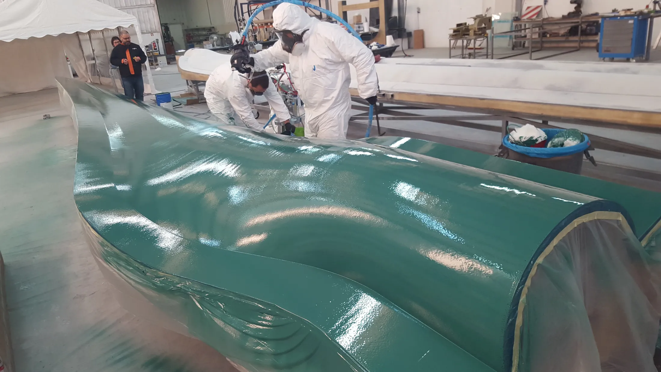 "Technicians applying Scott Bader gelcoats to a large composite structure in a manufacturing facility, showcasing marine application" [G]