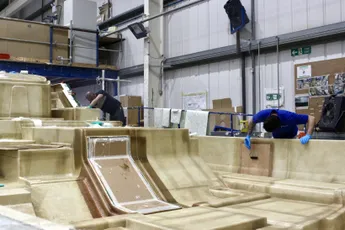Workers building boat hulls with Scott Bader composites and gelcoats in a marine manufacturing facility. [G]