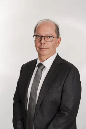 Professional portrait of a Scott Bader representative in a dark suit against a white background. [G]