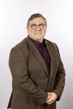 Professional portrait of a Scott Bader team member in a brown tweed jacket and burgundy shirt against a white background. [G]