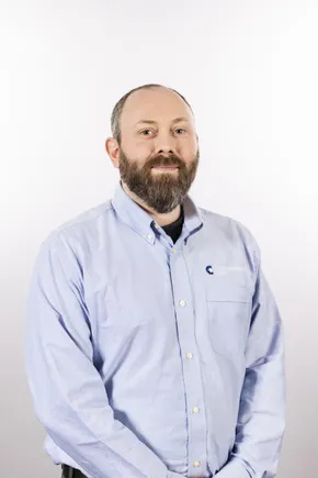 Professional portrait of a Scott Bader team member in a light blue button-up shirt with company logo visible [G]