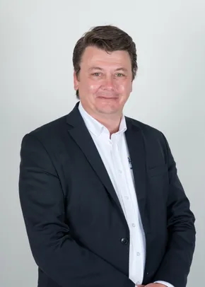 "Professional portrait of a Scott Bader representative in a dark suit against a light background" [G]