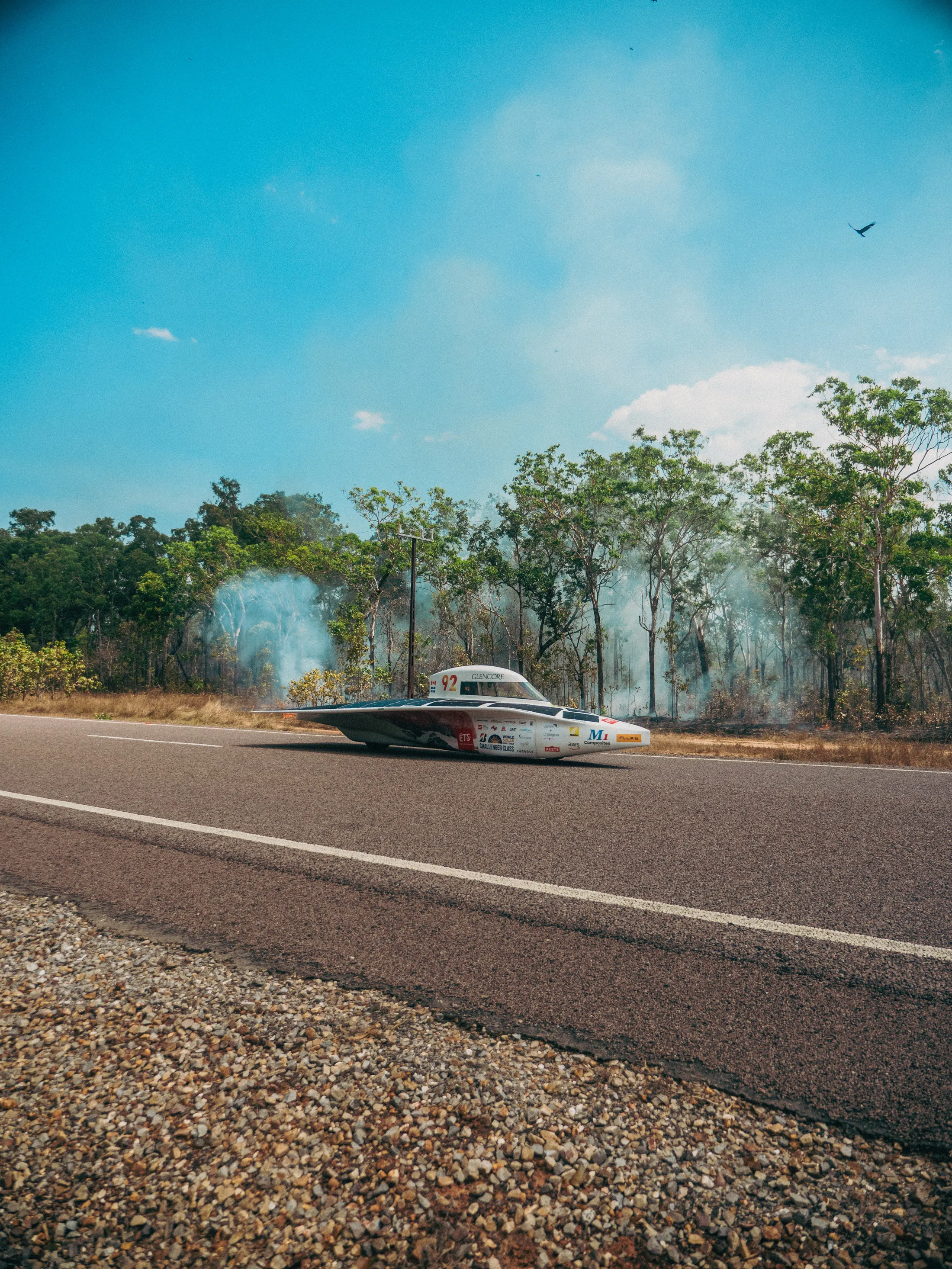 Solar-powered race car on road, built with Scott Bader composites and lightweight resins for performance. [G]