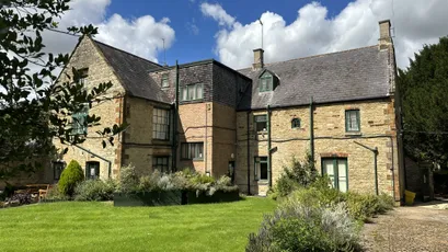 Historic stone building and headquarters of Scott Bader, maker of composites, gelcoats, and resins. [G]