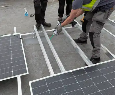 "Workers installing solar panels on metal framework using Scott Bader structural adhesives for secure mounting" [G]