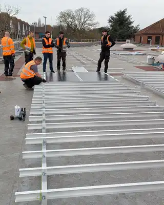 "Construction team installing metal framework on a concrete surface, using Scott Bader structural adhesives for durable assembly" [G]