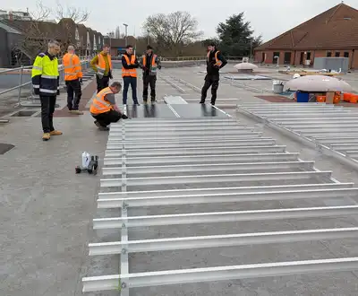 "Construction team installing metal framework on a concrete surface, using Scott Bader structural adhesives for durable assembly" [G]