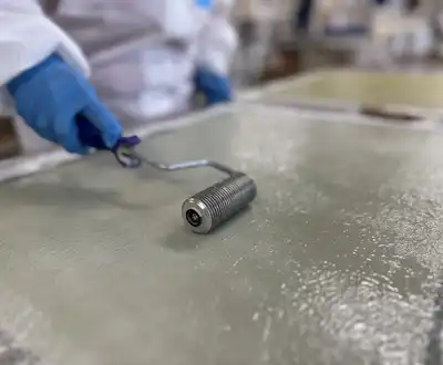 "Technician applying Scott Bader gelcoats to a surface using a roller for smooth, protective composite finishing" [G]