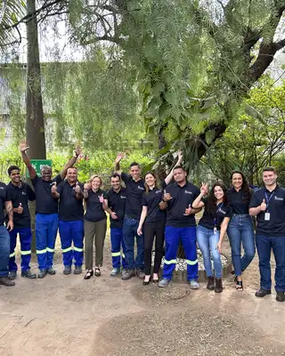 "Scott Bader team in matching uniforms gathered outdoors at industrial facility, showcasing company culture" [G]